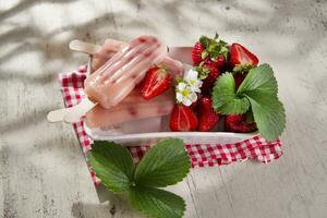 a plate with two popsicles on it and strawberries photo