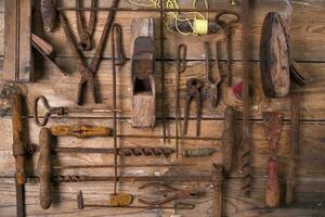 a group of rusty old tools sitting on a wall photo