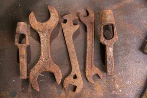 a group of rusty old tools sitting on a wall photo