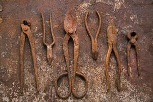 un grupo de oxidado antiguo herramientas sentado en un pared foto