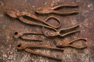 a group of rusty old tools sitting on a wall photo