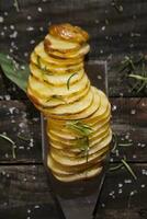 a knife and a bunch of sliced potatoes on a wooden table photo