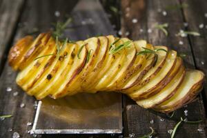 a knife and a bunch of sliced potatoes on a wooden table photo