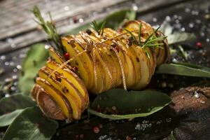 a pile of potatoes with herbs and spices on a wooden table photo