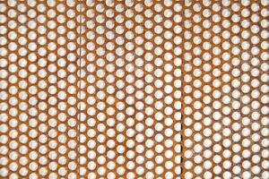 a close up of a metal mesh with holes photo