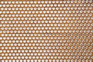 a close up of a metal mesh with holes photo
