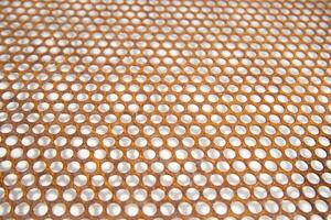 a close up of a metal mesh with holes photo