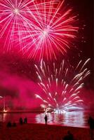 fireworks over the water at night photo