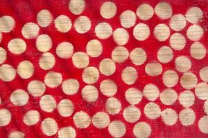 a red and white polka dot pattern on a wooden surface photo