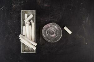 a pile of colored chalk sticks on a black table photo