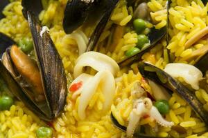 a plate of rice with mussels and other seafood photo