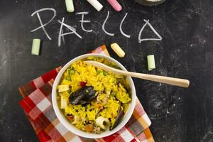 rice with mussels and vegetables on a black tablecloth with chalkboard rice photo