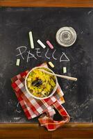 rice with mussels and vegetables on a black tablecloth with chalkboard rice photo