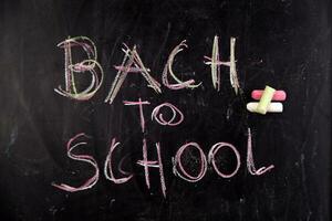 back to school written on blackboard with chalk photo