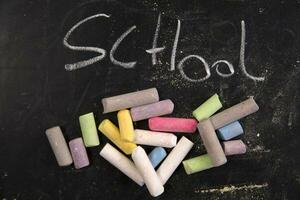 chalk and crayons on a blackboard stock photo