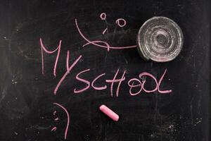 back to school written on blackboard with chalk photo