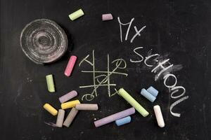 chalk and crayons on a blackboard stock photo