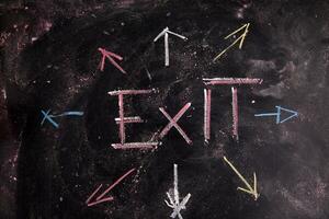 exit sign on blackboard with arrows photo