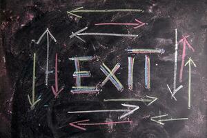 exit sign on blackboard with arrows photo