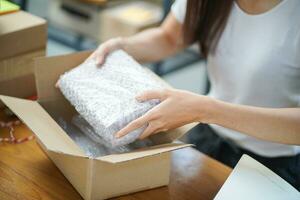 asiático mujer preparando paquete entrega caja Envío para compras en línea entrega correo Servicio personas y envío concepto foto