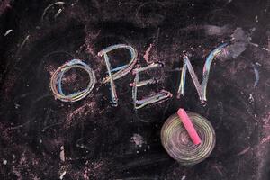 open written on a blackboard with chalk photo