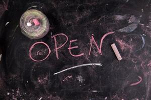 open written on a blackboard with chalk photo