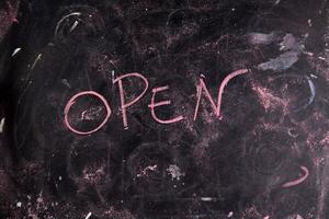 open written on a blackboard with chalk photo