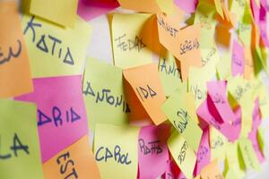 a wall covered with sticky notes with different words photo