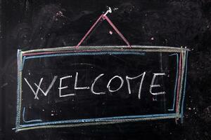 a chalkboard with the word welcome written on it photo