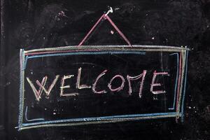 a chalkboard with the word welcome written on it photo