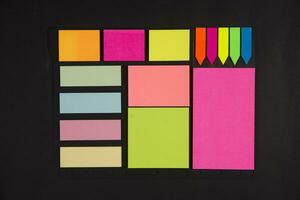 many colorful sticky notes on a black surface photo