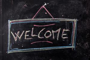 a chalkboard with the word welcome written on it photo