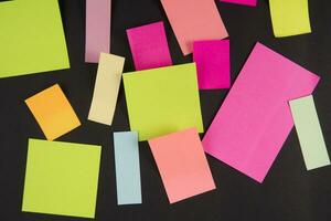 many colorful sticky notes on a black surface photo