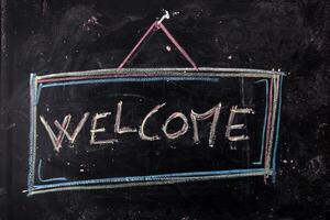 a chalkboard with the word welcome written on it photo