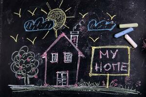 a chalkboard with a house, a sign and a sun photo