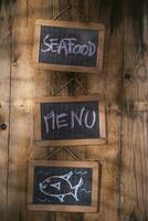 three blackboards with the words seafood menu and fish on them photo