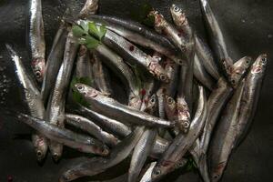 un pila de sardinas con perejil en parte superior foto