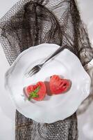 a white plate with a heart shaped piece of watermelon and a fork photo