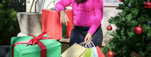 Happy asian girl hold shopping bags Xmas present. cheerful woman with Christmas New Year Winter sale photo