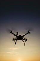 Quadrocopter in flight at sunset photo