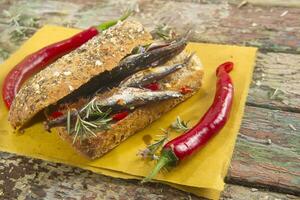 a sandwich with peppers and herbs on a napkin photo