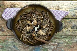 plato de horneado alcachofas con enebro bayas foto