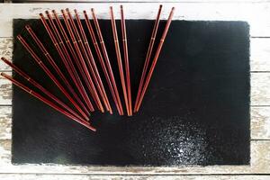 palillos para Sushi en un negro antecedentes foto