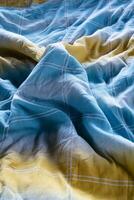 Colorful blanket in an unmade bed and grazing light photo