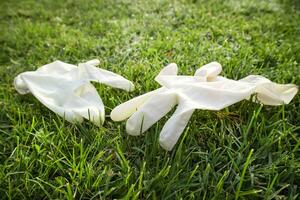 Disposable anti Coronavirus gloves thrown on the ground photo