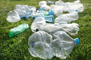 Used plastic bottles abandoned in a meadow photo