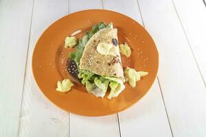 Vegan cuisine presentation of a mayonnaise and salad flatbread photo