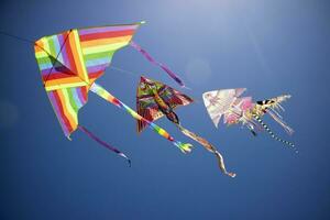 Series of colorful kites flying in the blue sky photo