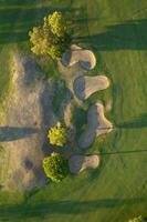 aéreo ver de un verde golf curso a puesta de sol foto