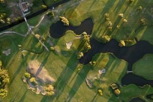 Aerial view of a green golf course at sunset photo